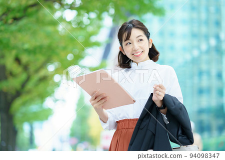 一個穿著辦公室休閒服在戶外工作的女人 94098347