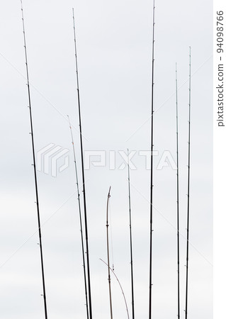 Row of fishing rods. Hunting and fishing. Cloudy weather Row of fishing rods. Hunting and fishing. Cloudy weather 94098766