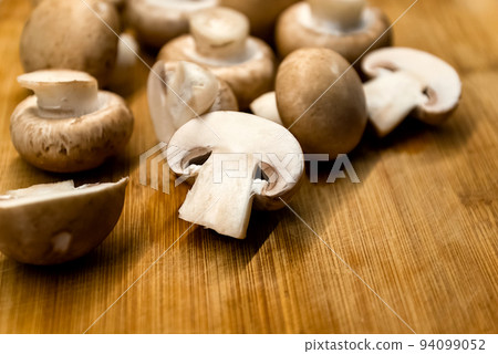 Fresh champignons mushrooms on wooden cutting board Fresh champignons mushrooms on wooden cutting board 94099052