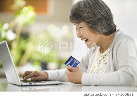 Senior woman enjoying online shopping on a computer Senior woman enjoying online shopping on a computer 94100651