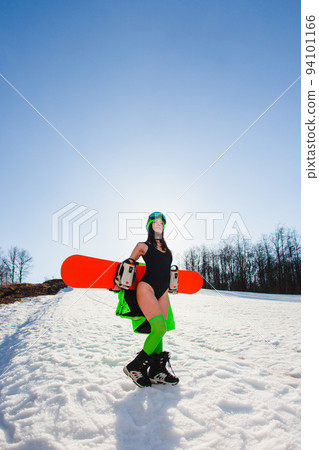 Young beautiful woman posing with a snowboard on a ski slope 94101166