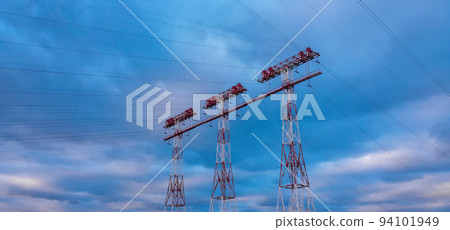 High voltage lines and power pylons in a sunset. landscape with clouds and blue sky. High voltage lines and power pylons in a sunset. landscape with clouds and blue sky. 94101949