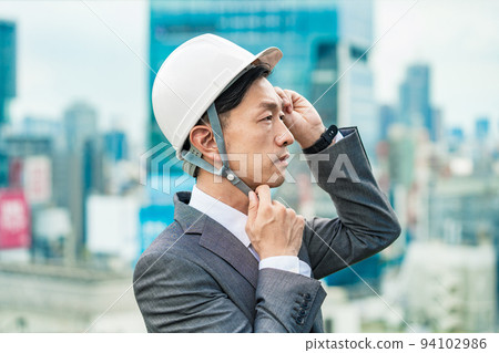 A businessman wearing a helmet A businessman wearing a helmet 94102986