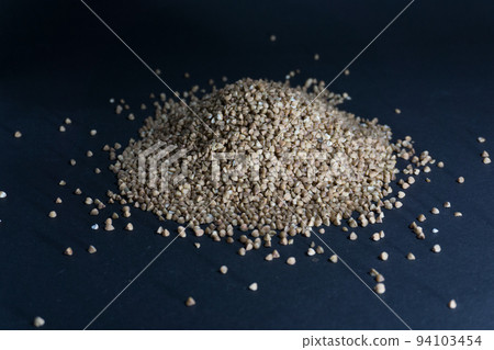 Scattered buckwheat grains on a black background Scattered buckwheat grains on a black background 94103454