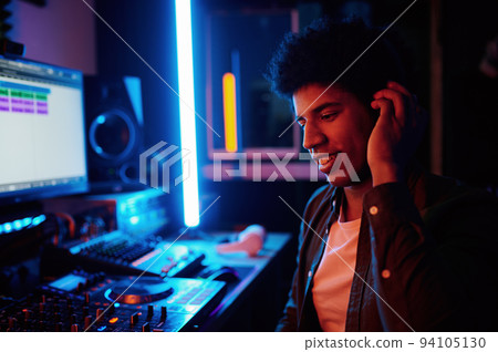 Glad music producer listening new track in headphones Glad music producer listening new track in headphones 94105130