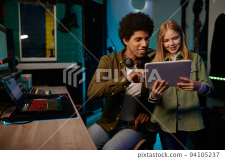 Audio engineer with young singer working in music recording studio Audio engineer with young singer working in music recording studio 94105237