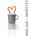 Cocoa with marshmallows and two heart-shaped Candy canes in a gray cup isolated on a white background with reflection. A Christmas gift, a traditional drink for a cozy winter evening. 94105723