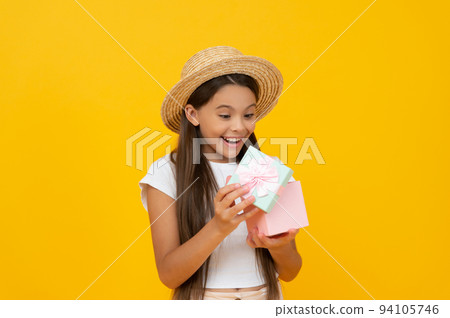 shocked teen kid hold present box on yellow background 94105746
