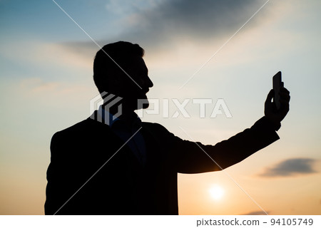 businessman silhouette making selfie on phone on sky background. confidence and success. successful future. agile business. loneliness. need the inspiration. man feel motivation. modern technology 94105749