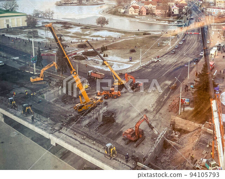 construction of a bridge in the city center. construction of a new overpass on a fenced section of the road. view from a height of a large construction site 94105793