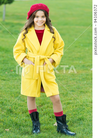 Fancy coat. Classic coat does not have to be boring but sticking to scale of warm, understated tones. Girl fashionable model wear yellow wool coat. Child in warm clothes. Feeling cozy and comfortable 94106372