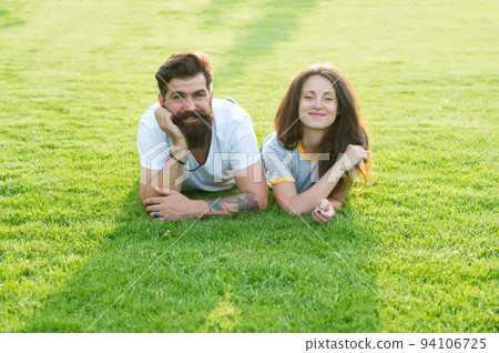 Carefree couple enjoying sunny day relaxing on green meadow, summer vacation concept 94106725