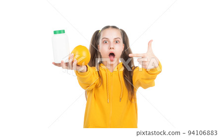 kid pointing finger on orange fruit and vitamin pill in jar bottle isolated on white, surprise. kid pointing finger on orange fruit and vitamin pill in jar bottle isolated on white, surprise. 94106883