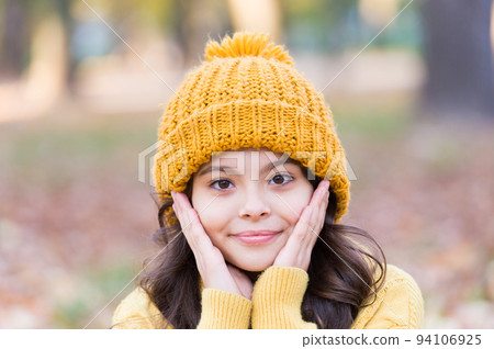 Autumn skin care. Little child wear hat on autumn landscape. Small girl touch clean pure skin. Organic cosmetics for skin. Natural beauty. Adapt kids skin for autumn weather 94106925