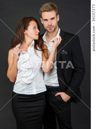 formal couple in love in business look together on black background, leadership 94107273