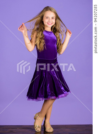 Kids fashion. Kid fashionable dress looks adorable. Ballroom dancewear fashion concept. Kid dancer satisfied with concert outfit. Girl cute child wear velvet violet dress. Clothes for ballroom dance 94107285