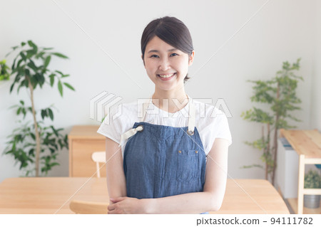 A woman with a smile wearing an apron 94111782