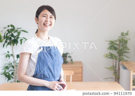A woman with a smile wearing an apron 94111970