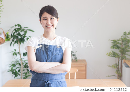 一個穿著圍裙、雙臂交叉的微笑女人 94112212
