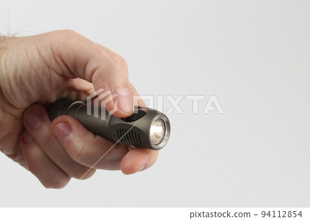hand holds included a small flashlight on a white background 94112854
