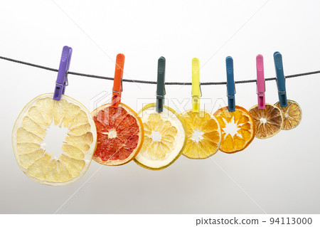 dried pieces of citrus fruits hang on clothespins 94113000