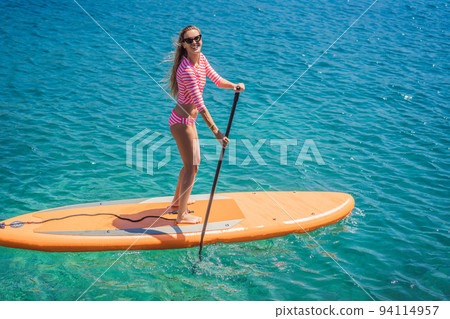 Young women Having Fun Stand Up Paddling in blue water sea in Montenegro. SUP. girl Training on Paddle Board near the rocks Portrait of a disgruntled girl sitting at a cafe table 94114957