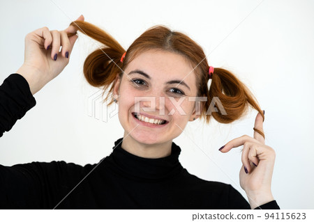 Closeup portrait of a funny redhead teenage girl with childish hairstyle smiling happily isolated on white backround. Closeup portrait of a funny redhead teenage girl with childish hairstyle smiling happily isolated on white backround. 94115623