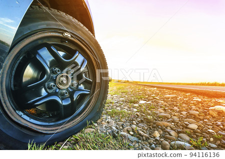 Close up of flat tire on a car on gravel road. 94116136