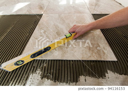 Ceramic tiles and tools for tiler. Floor tiles installation. Home improvement, renovation - ceramic tile floor adhesive, mortar, level Ceramic tiles and tools for tiler. Floor tiles installation. Home improvement, renovation - ceramic tile floor adhesive, mortar, level 94116153