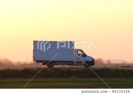 Cargo truck driving on highway hauling goods in evening. Delivery transportation and logistics concept 94116156