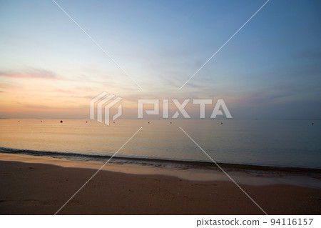 Calm sea shore with crushing waves on sandy beach at sunrise. 94116157