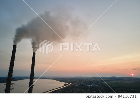 Aerial view of coal power plant high pipes with black smokestack polluting atmosphere. Electricity production with fossil fuel concept Aerial view of coal power plant high pipes with black smokestack polluting atmosphere. Electricity production with fossil fuel concept 94116731