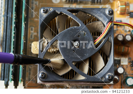 Cleaning dirty desktop computer processor fan from dust by special brush close up. Cleaning dirty desktop computer processor fan from dust by special brush close up. 94121233