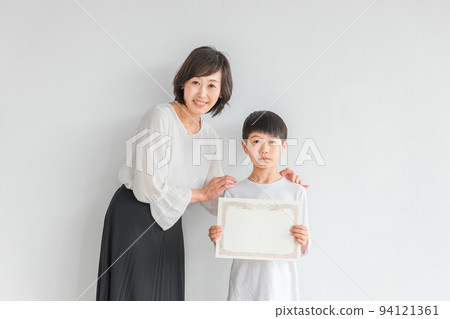 A boy with a certificate and a smiling Japanese woman (teacher/mother) A boy with a certificate and a smiling Japanese woman (teacher/mother) 94121361