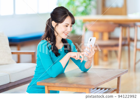 Women's living room smartphone lifestyle casual 94122992