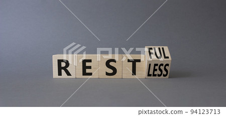 Restful and Restless symbol. Turned wooden cubes with words Restless and Restful. Beautiful grey background. Business concept. Copy space Restful and Restless symbol. Turned wooden cubes with words Restless and Restful. Beautiful grey background. Business concept. Copy space 94123713