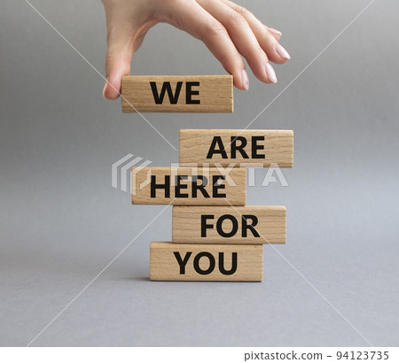 Help symbol. Wooden blocks with words 'We are here for you'. Beautiful grey background. Businessman hand. Business and 'We are here for you' concept. Copy space. 94123735