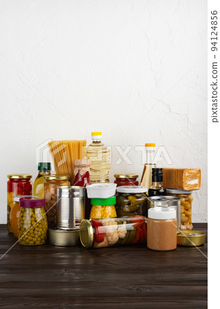 Emergency survival food set on dark wooden kitchen table 94124856