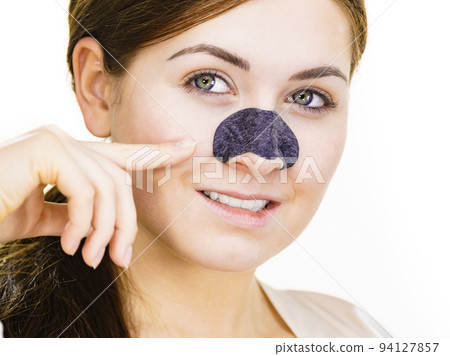 Woman applying pore strips on nose 94127857