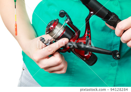 Person holding fishing rod, spinning equipment. Person holding fishing rod, spinning equipment. 94128284