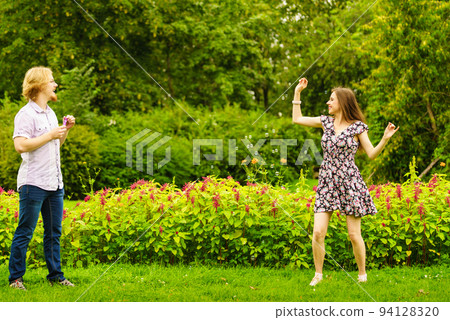 Couple blowing bubbles outdoor Couple blowing bubbles outdoor 94128320