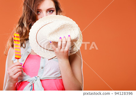 woman in summer hat eating ice pop cream woman in summer hat eating ice pop cream 94128396
