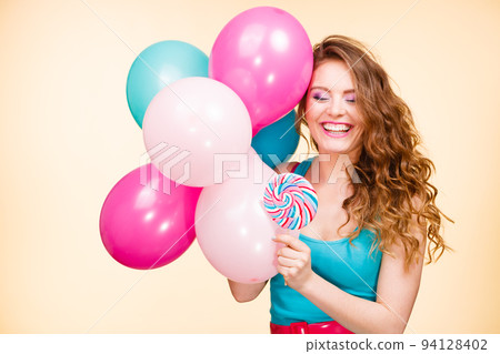 Woman with colorful balloons and lollipop Woman with colorful balloons and lollipop 94128402