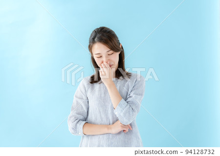A woman holding her nose Blue back A woman holding her nose Blue back 94128732