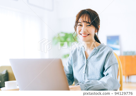 A woman using a personal computer at home A woman using a personal computer at home 94129776