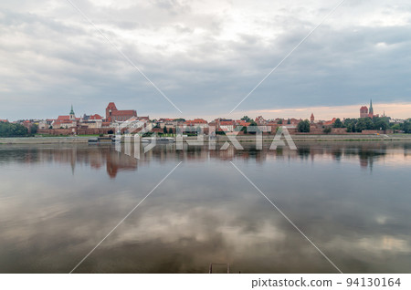 Morning view of panoramic view on Old town of Torun city walls and reflection in Vistula river. 94130164