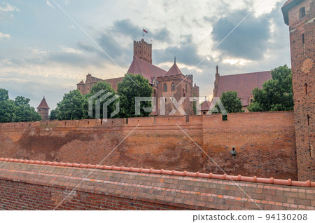 Sunset on High Castle and St. Mary church of the medieval Teutonic Order Castle in Malbork, Poland. 94130208