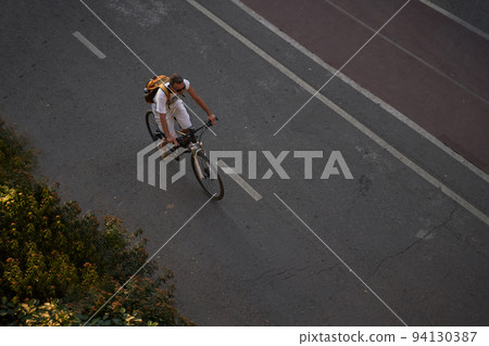 Man bicycling on cycling road. Top aerial view. Man bicycling on cycling road. Top aerial view. 94130387