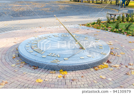 Sundial with autumn leaves in the park. 94130979