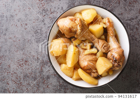 Indonesian cuisine chicken drumsticks stewed with potatoes in spicy sweet soy sauce close-up. horizontal top view 94131617